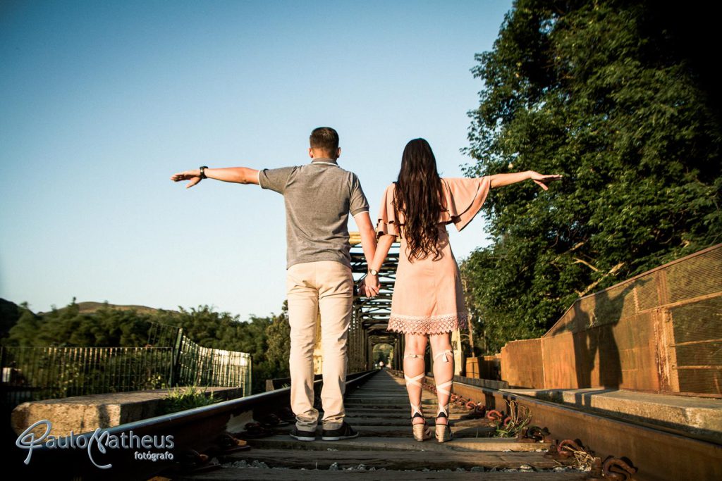Fotografia na linha do trem em ensaio fotográfico para casal